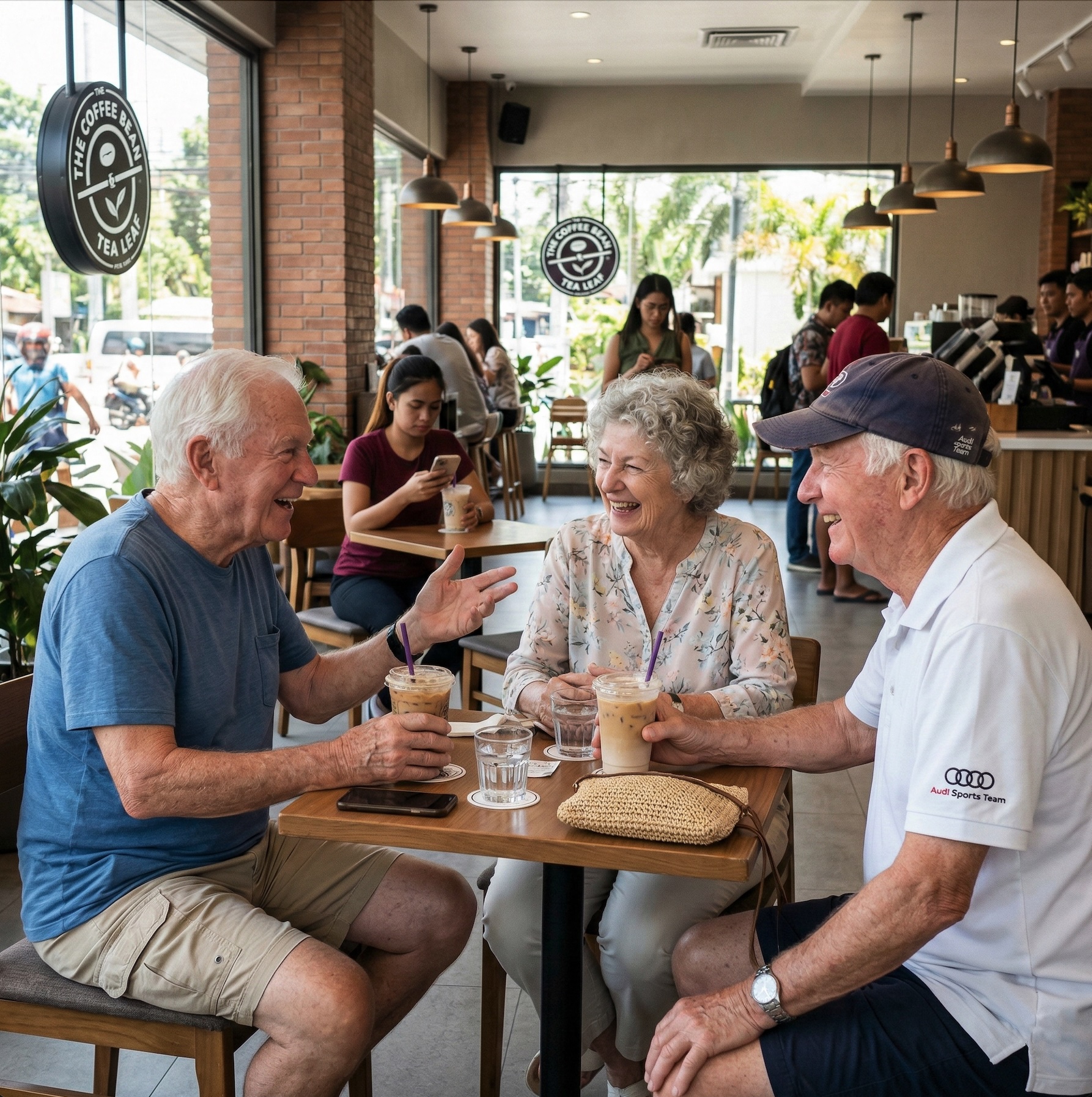 Three elderly Western expats laughing over iced coffees at a modern café in the Philippines, with a Filipina caregiver relaxing nearby